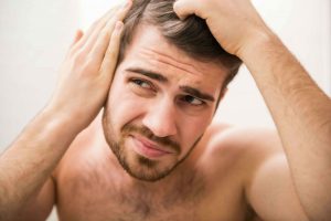 Man looking at potential bald spot